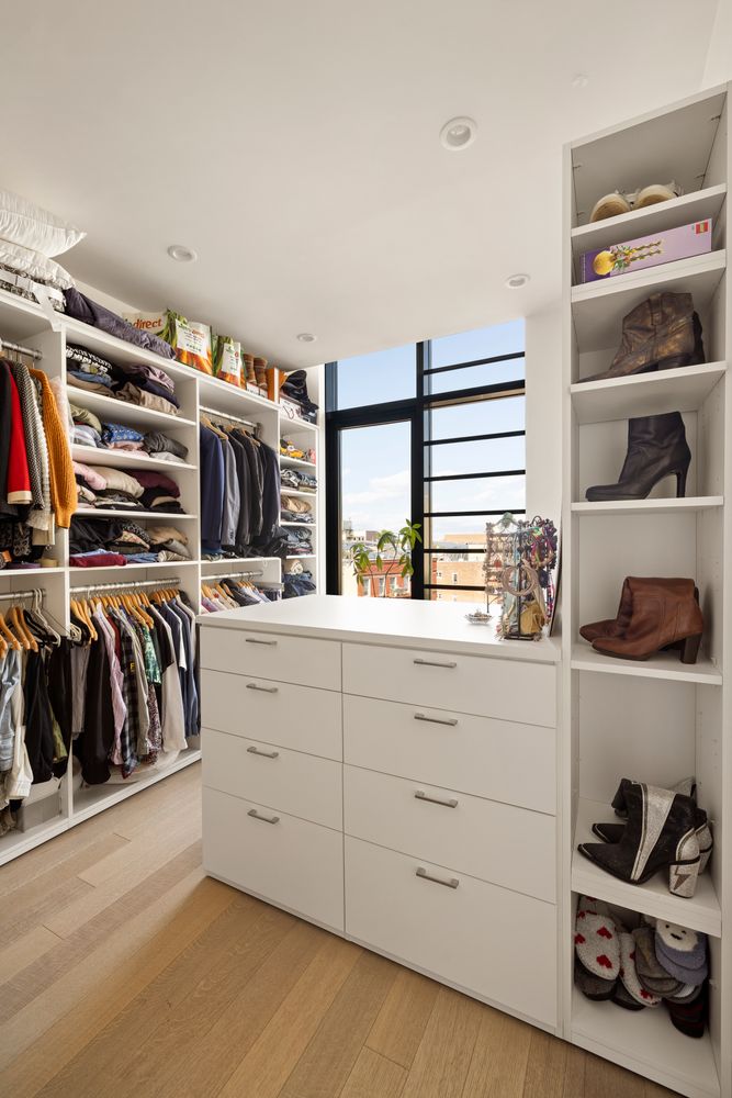 Walk in closet with custom shelving, drawers, and window